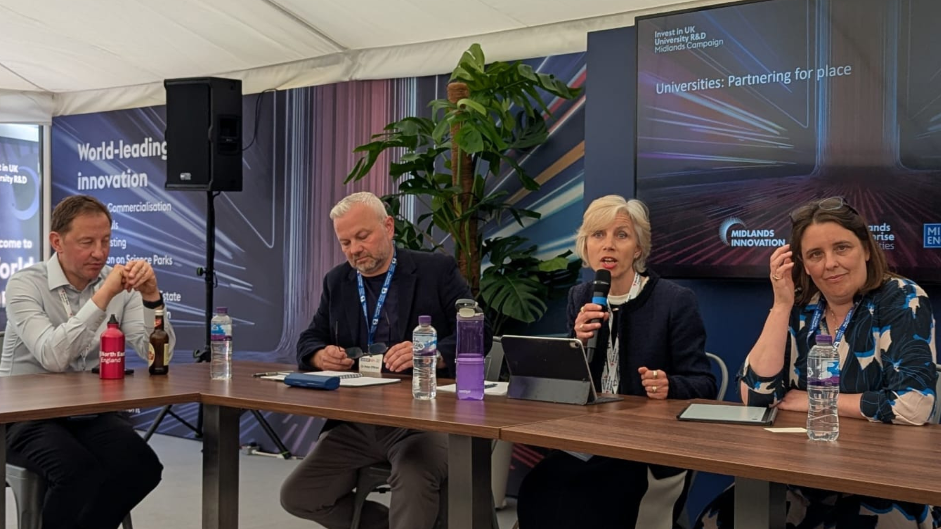 Four people sat at a table with a mic during a conference.