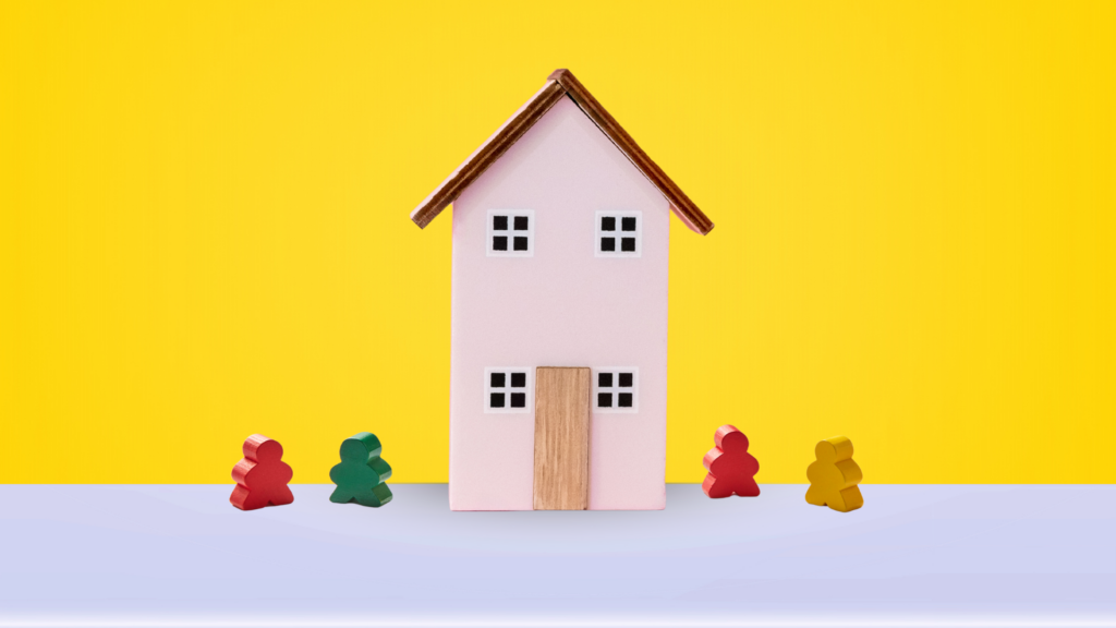 Wooden toy people outside a house.