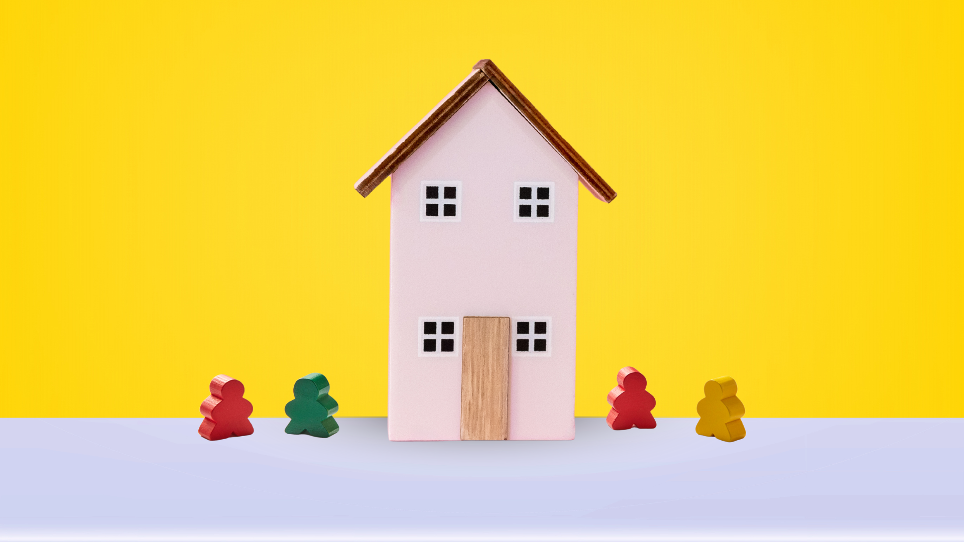 Wooden toy people outside a house.